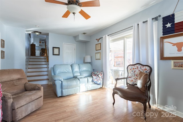 living room featuring ceiling fan and light hardwood / wood-style flooring