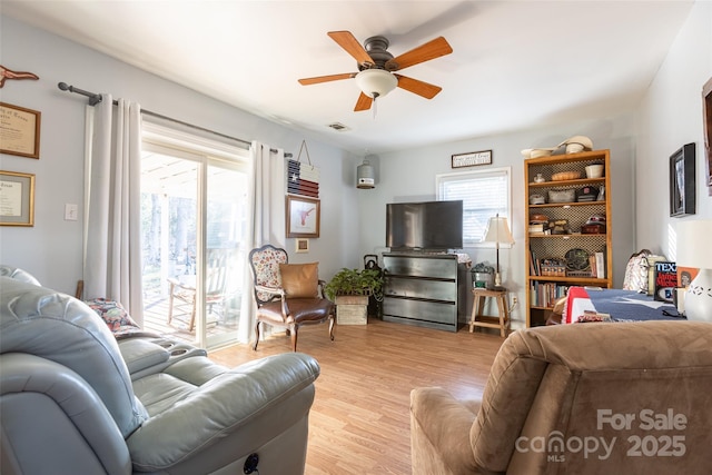 living room featuring ceiling fan, light hardwood / wood-style flooring, and a wealth of natural light