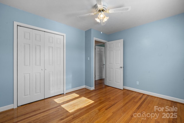 unfurnished bedroom featuring ceiling fan, a closet, and light wood-type flooring