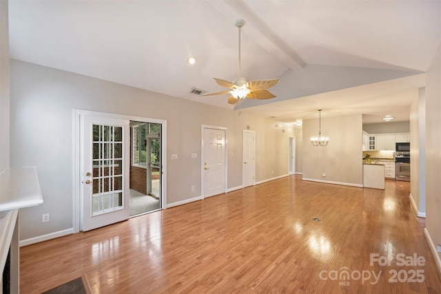 unfurnished living room with ceiling fan with notable chandelier, light hardwood / wood-style floors, and vaulted ceiling with beams