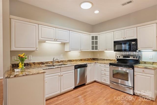 kitchen featuring stainless steel appliances, sink, white cabinets, and light hardwood / wood-style flooring