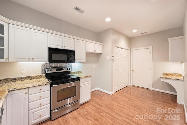 kitchen with light wood-type flooring, light stone countertops, white cabinets, and stainless steel electric range oven