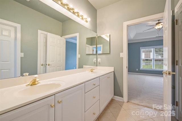 bathroom with ceiling fan, vanity, a raised ceiling, and tile patterned flooring