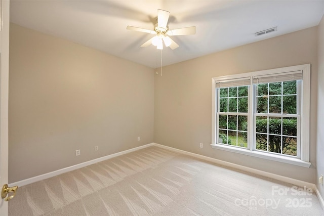 carpeted spare room with ceiling fan