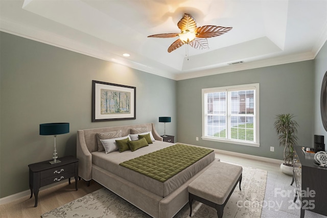 bedroom featuring a raised ceiling, crown molding, and ceiling fan