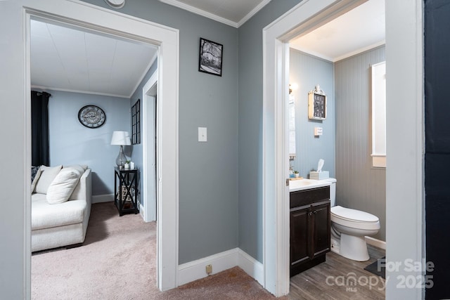 bathroom with crown molding, vanity, and toilet