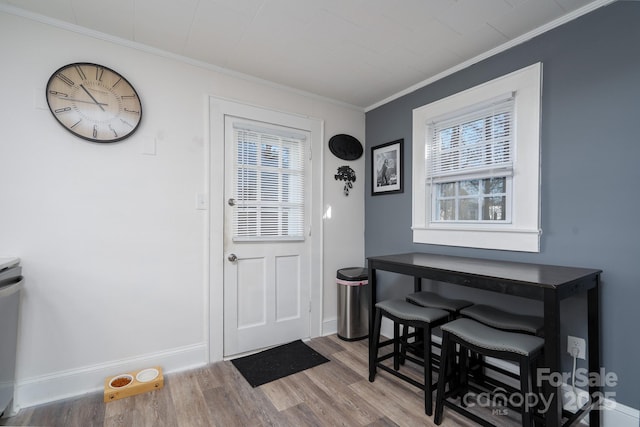 doorway to outside with hardwood / wood-style flooring and ornamental molding