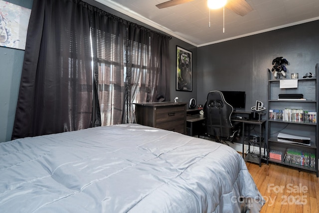 bedroom featuring hardwood / wood-style flooring, crown molding, and ceiling fan