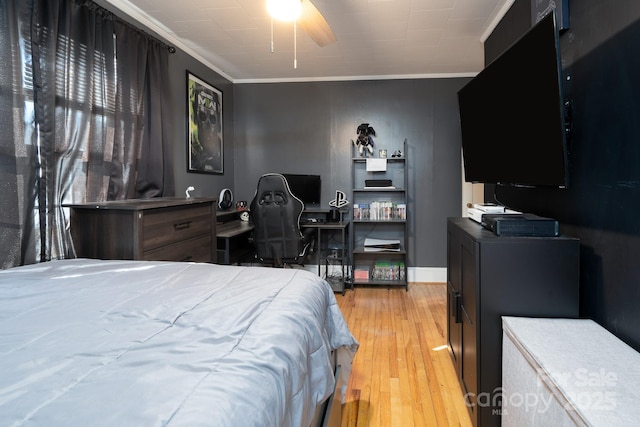 bedroom featuring light hardwood / wood-style flooring, ornamental molding, and ceiling fan