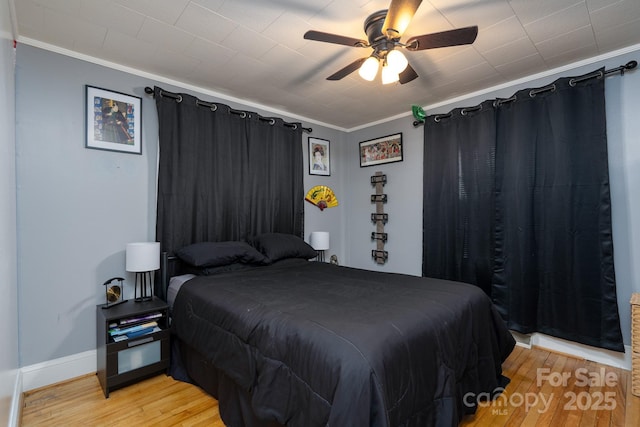 bedroom featuring crown molding, ceiling fan, and light hardwood / wood-style floors