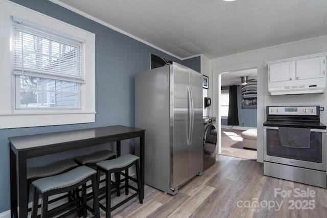 kitchen featuring crown molding, stainless steel appliances, white cabinets, washer / dryer, and light wood-type flooring