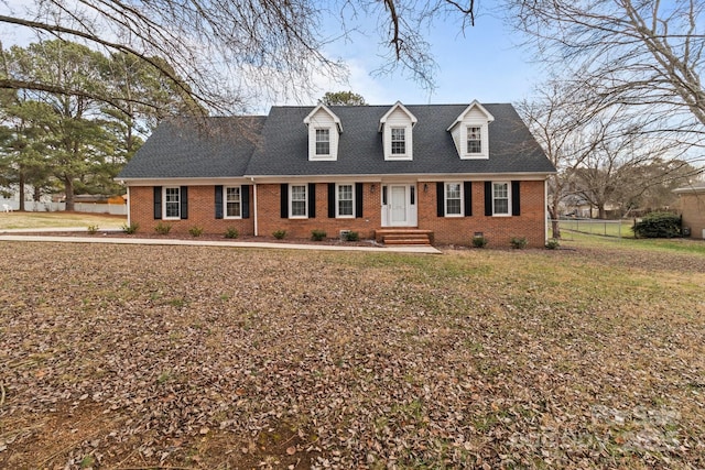 cape cod home with a front yard