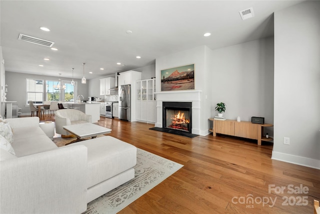 living room featuring sink and light wood-type flooring