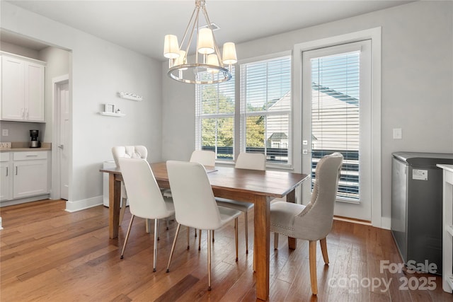 dining area with plenty of natural light, a notable chandelier, and light hardwood / wood-style floors