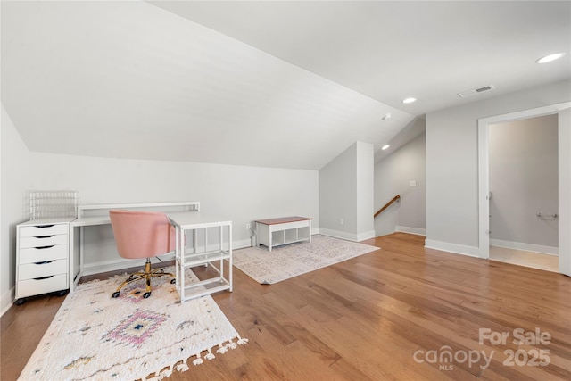 unfurnished office with vaulted ceiling and wood-type flooring