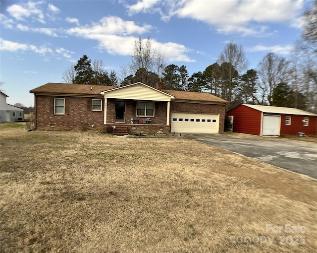 single story home with an outbuilding, a porch, a garage, and a front yard