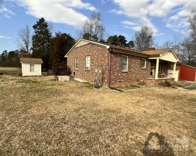 view of home's exterior featuring a yard, covered porch, and a storage unit