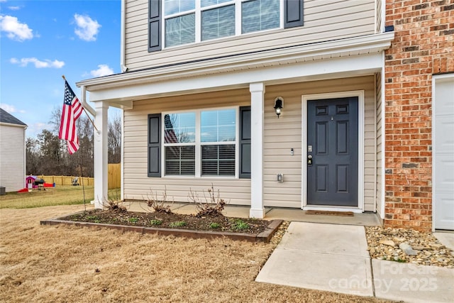 doorway to property with a garage and covered porch