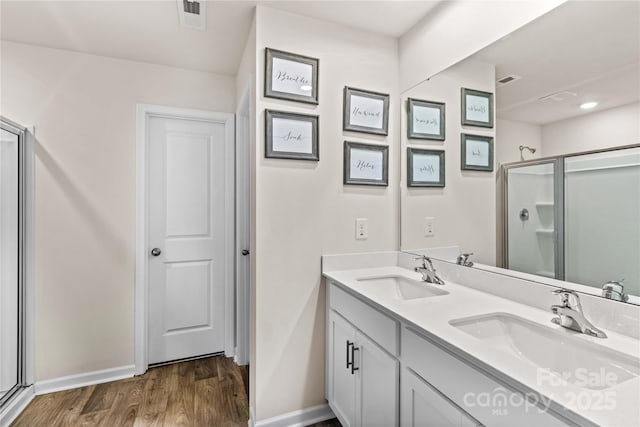 bathroom featuring vanity, wood-type flooring, and walk in shower