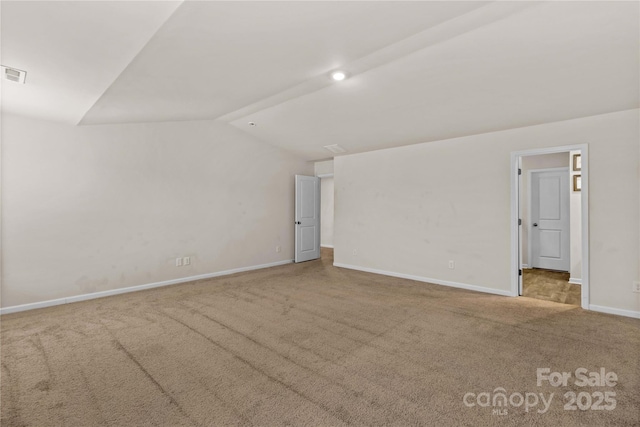 carpeted spare room with lofted ceiling