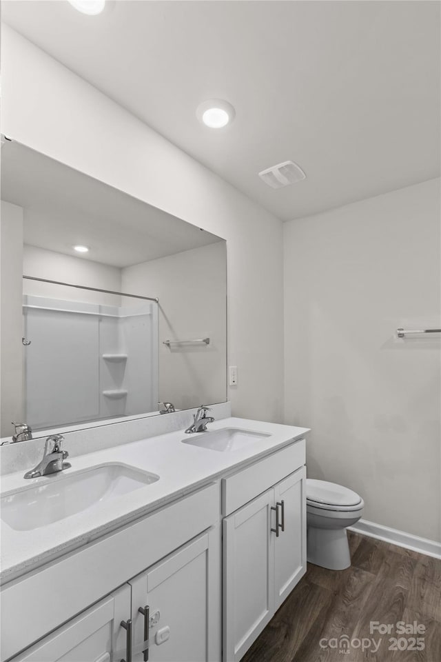 bathroom with vanity, wood-type flooring, toilet, and walk in shower