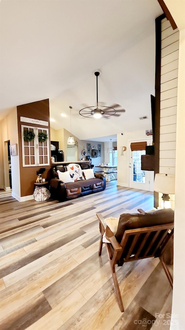 living room featuring lofted ceiling, hardwood / wood-style floors, and ceiling fan