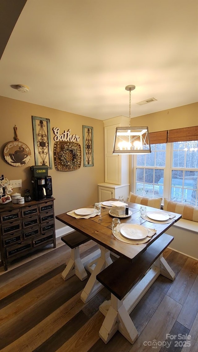 dining area with a notable chandelier and dark wood-type flooring