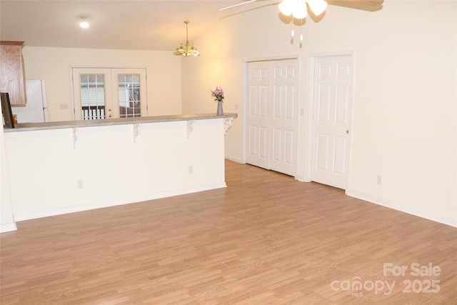 interior space featuring french doors, ceiling fan, vaulted ceiling, and light wood-type flooring