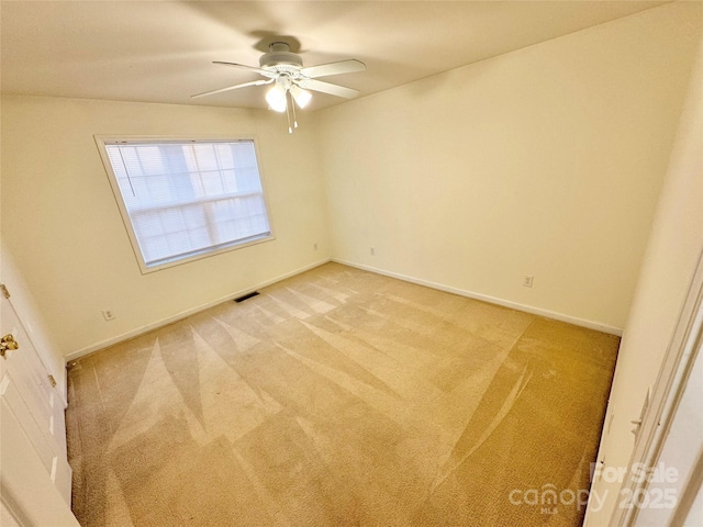 spare room featuring ceiling fan and carpet