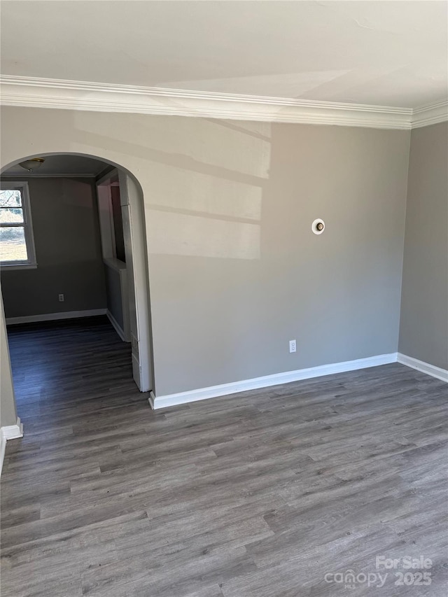 spare room featuring ornamental molding and dark hardwood / wood-style floors