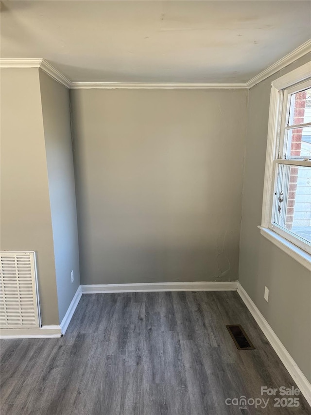 empty room featuring crown molding and dark hardwood / wood-style flooring