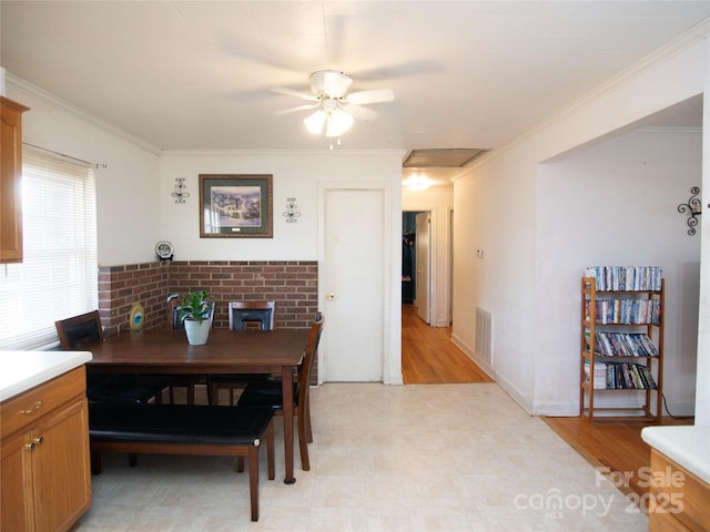 dining space with ornamental molding and ceiling fan