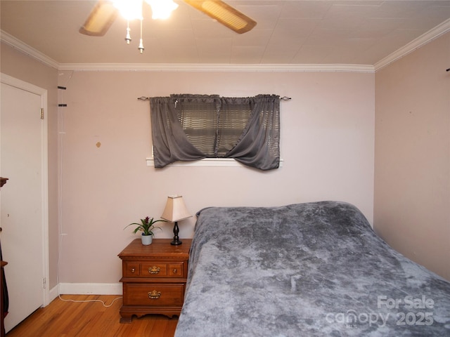 bedroom with ornamental molding, ceiling fan, and light hardwood / wood-style flooring