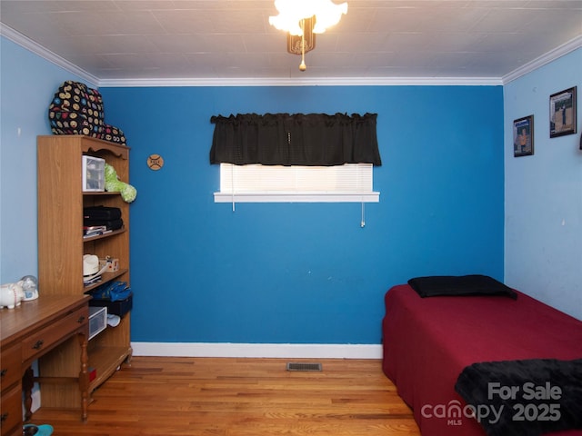 bedroom featuring crown molding and wood-type flooring