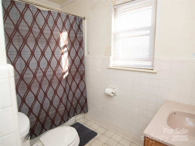 bathroom featuring toilet, crown molding, tile walls, vanity, and tile patterned flooring