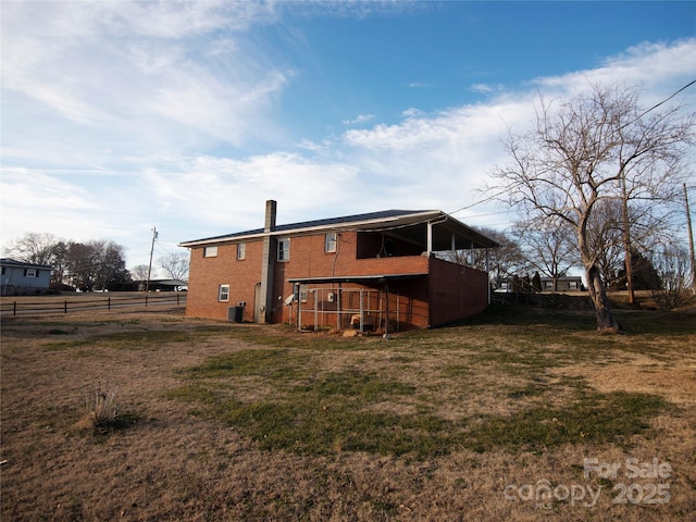 back of property with cooling unit and a lawn