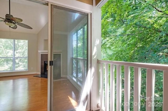 doorway to outside with lofted ceiling, hardwood / wood-style flooring, and ceiling fan