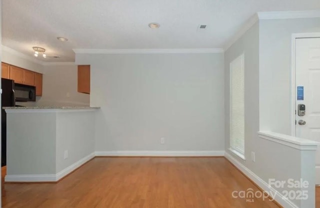 interior space featuring ornamental molding, light hardwood / wood-style floors, and kitchen peninsula