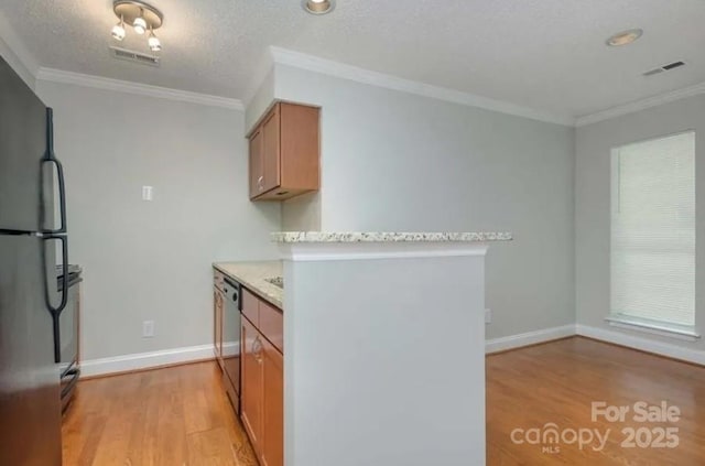 kitchen with ornamental molding, fridge, a textured ceiling, and light wood-type flooring