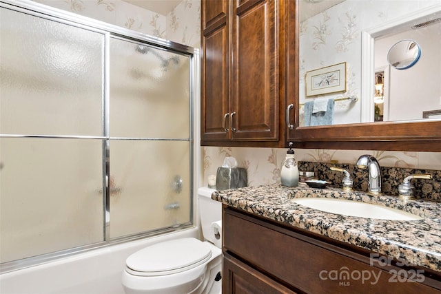 full bathroom with vanity, shower / bath combination with glass door, and toilet