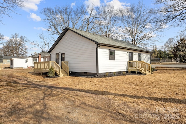 view of side of home with a yard and a deck