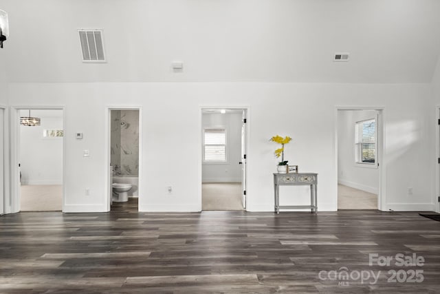 unfurnished living room with a wealth of natural light and dark hardwood / wood-style floors