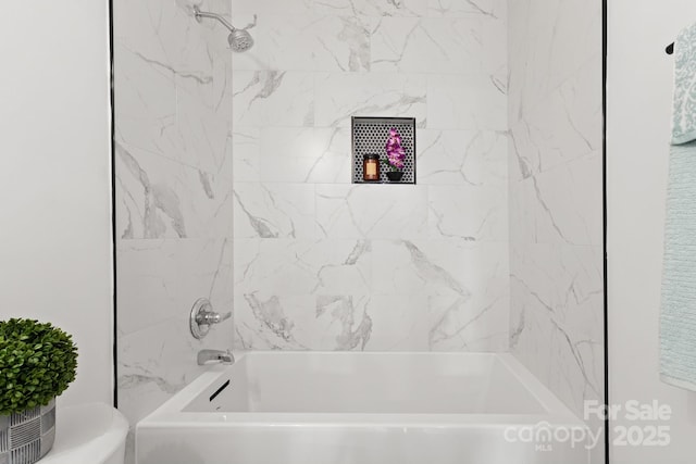 bathroom featuring toilet and tiled shower / bath combo