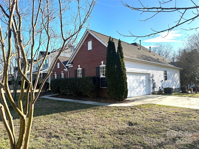 view of side of property featuring a garage, central AC unit, and a lawn