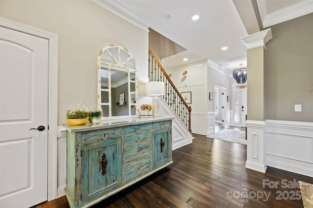 interior space featuring dark wood-type flooring, ornamental molding, and ornate columns