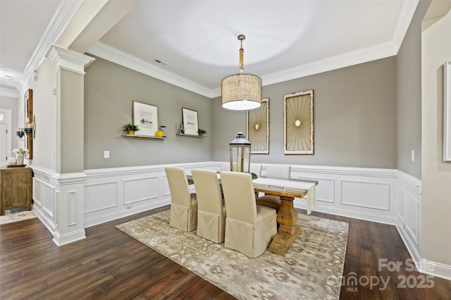 dining space featuring ornate columns, crown molding, and dark hardwood / wood-style floors