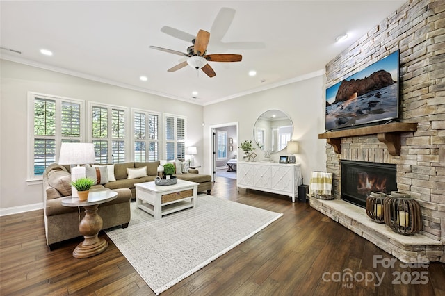 living room featuring ceiling fan, ornamental molding, dark hardwood / wood-style floors, and a stone fireplace