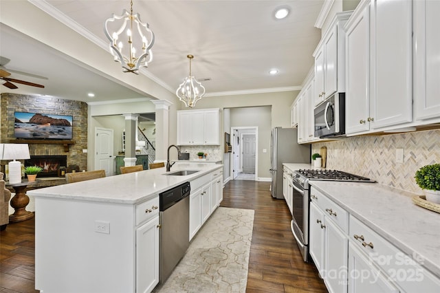 kitchen featuring white cabinetry, sink, decorative light fixtures, and stainless steel appliances