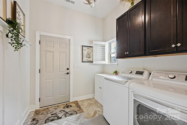 washroom featuring cabinets and separate washer and dryer