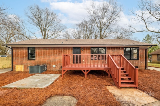 back of property featuring cooling unit, a wooden deck, and a patio